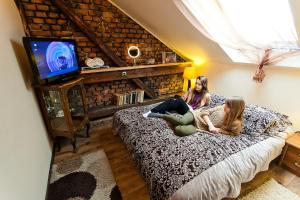 Due ragazze sedute su un letto in una stanza di Apartament Pool SPA z jacuzzi a Strzyżów