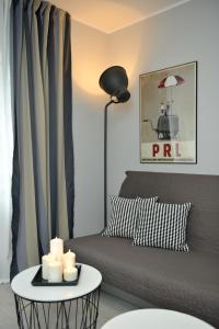 a living room with a couch and a table with candles at Apartamenty TOP Garbary in Poznań