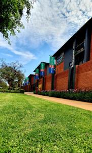 a building with a green lawn in front of it at Hotel AT Hatfield Apartments in Pretoria