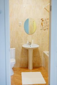 bagno con lavandino, servizi igienici e specchio di Sarai-Batu Guest House a Atyraū