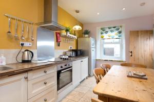 a kitchen with a wooden table and a counter top at Hexham Cottage in Seahouses