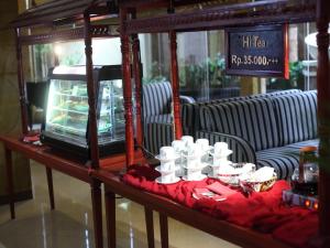 a table with white cups on a red cloth at Le Dian Hotel in Serang