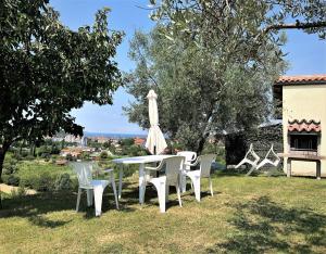 a table and chairs and an umbrella in the grass at Residence Villa Fiore Portorož in Portorož