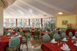 ein Restaurant mit Tischen, Stühlen und roten Tischdecken in der Unterkunft Hotel Marco Polo in Garda