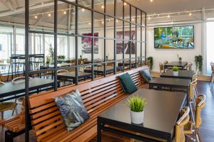 um restaurante com mesas e bancos numa sala em Cabinn Aarhus em Arhus