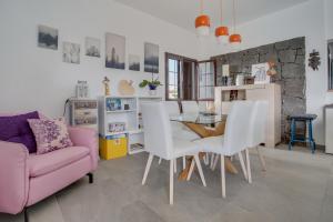 Villa Kodotoma في يايثا: غرفة معيشة مع طاولة وأريكة وردية