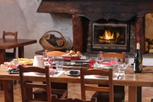 a dining room table with a bottle of wine and a fireplace at Au Coeur Des Alpes in Villarodin-Bourget