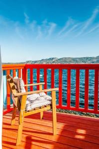 a wooden chair sitting on a deck overlooking the water at Dream Boathouse in Klima +23 photos
