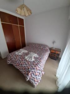 um quarto com uma cama com duas toalhas em Sueños del Golfo em Puerto Madryn