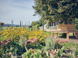 a park bench sitting in a garden with flowers at Lehnerhof in Bad Aibling