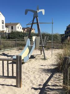 a playground with a slide in the sand at Les Pieds dans l'Eau in Lacanau-Océan