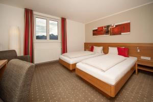 una habitación de hotel con 2 camas y una silla en Seehof Innsbruck en Innsbruck