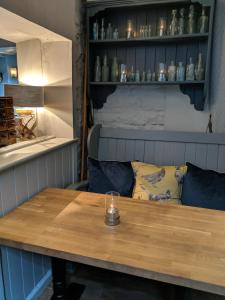 a wooden table with a candle on top of it at The Keepers Arms in Quenington