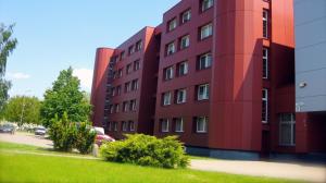 ein rotes Gebäude mit davor geparkten Autos in der Unterkunft "AVA" apgyvendinimo įstaiga in Vilnius
