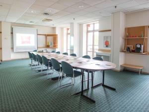 ein großer Konferenzraum mit einem langen Tisch und Stühlen in der Unterkunft ibis Grenoble Centre Bastille in Grenoble