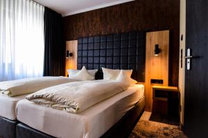 1 Schlafzimmer mit 2 Betten und einem großen Fenster in der Unterkunft Hotel Roter Löwe in Ulm