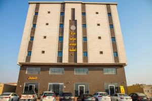 Un grand bâtiment avec des voitures garées dans un parking dans l'établissement Durra Taraf Residential 2, à Dammam