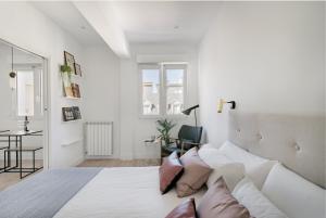 Habitación blanca con cama grande y escritorio. en Apartamento Ecléctico en el centro de la ciudad, en San Sebastián