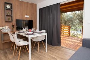 a dining room with a white table and chairs at Authentic Camping Dalmatia in Pirovac