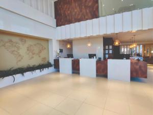 a large lobby with a reception desk and a counter at Mogano Express Hotel - PET FRIENDLY- ELETROPOSTO in Chapecó