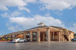 un edificio con dos coches estacionados en un estacionamiento en Quality Inn Russellville I-40, en Russellville