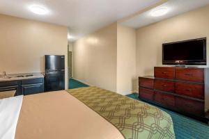 a hotel room with a bed and a flat screen tv at Econo Lodge Inn & Suites Granite City in Granite City
