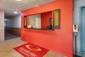 a red wall in a hallway with a mirror at Econo Lodge Inn & Suites in Granite City