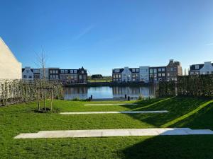 een park met gebouwen en een waterlichaam bij Gouda's Herenhuys in Gouda