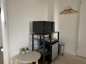 uma sala de estar com uma televisão numa bancada com uma mesa em Gouda's Herenhuys em Gouda