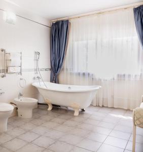 bagno bianco con vasca e servizi igienici di MOROZOVO Resort-Hotel&SPA a Berdsk
