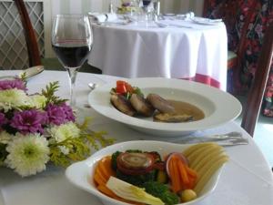 una mesa con dos platos de comida y una copa de vino en Simonsbath House Hotel en Simonsbath