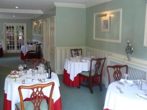 a dining room with two tables with red and white tablecloths at Simonsbath House Hotel in Simonsbath