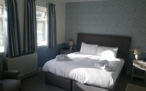 ファイリーにあるThe White Lodge Hotelのベッドルーム1室(大型ベッド1台、白いシーツ、枕付)