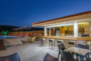 a patio with a bar and a swimming pool at night at Vanisko Hotel in Amoudara Herakliou