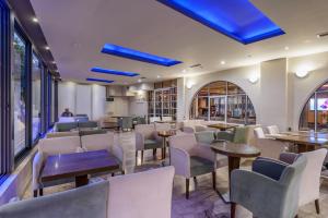 un restaurante con mesas, sillas y luces azules en Vanisko Hotel, en Amoudara Herakliou