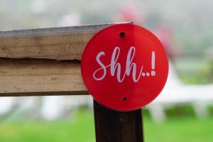 a red sign that says shhh on a wooden railing at Apartamentos Los Telares in Hermigua