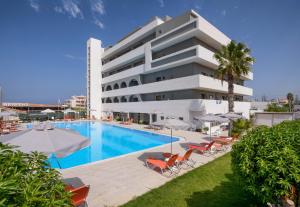 a hotel with a swimming pool and chairs and a building at Vanisko Hotel in Amoudara Herakliou