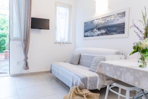 a white living room with a table and a couch at Pochi Passi dal Mare in San Bartolomeo al Mare