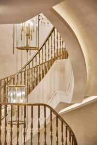 eine Treppe in einem Gebäude mit einem Kronleuchter in der Unterkunft Four Seasons Hotel Madrid in Madrid