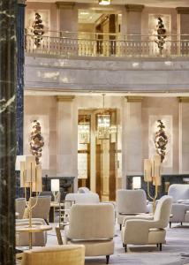 a lobby with chairs and tables and a building at Four Seasons Hotel Madrid in Madrid