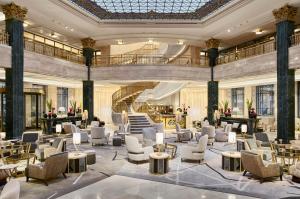 eine Lobby mit Stühlen und einer Wendeltreppe in der Unterkunft Four Seasons Hotel Madrid in Madrid