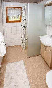 a bathroom with a sink and a toilet and a shower at Marbyfjärden seaside village Loftet in Eckerö