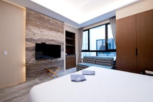 um quarto de hotel com uma cama grande e uma televisão de ecrã plano em Hu Shan Hot Spring Hotel em Tai'an