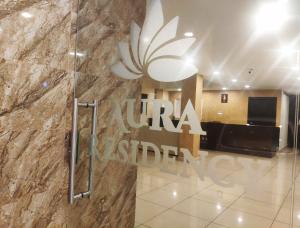 a lobby of a hotel with a sign on a wall at Aura Residency in Trichūr