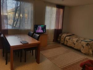 Pokój ze stołem, łóżkiem i telewizorem w obiekcie Salonkylän koulu w mieście Kaustinen