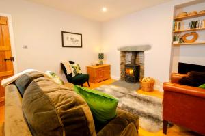 a living room with a couch and a fireplace at Juniper Cottage, Chapel Stile, Langdale in Chapel Stile