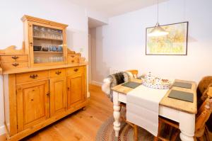 a dining room with a table and a wooden cabinet at Juniper Cottage, Chapel Stile, Langdale in Chapel Stile