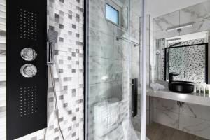 a bathroom with a glass shower and a sink at Golden Sunlight Hotel by Estia in Gouves