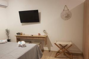 a room with a bed, table and television at Modern elegant apartment next to Mon Repo in Corfu