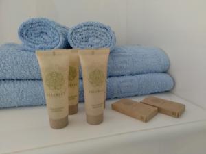 two bottles of moisturizing cream next to blue towels at La Familia in Loo